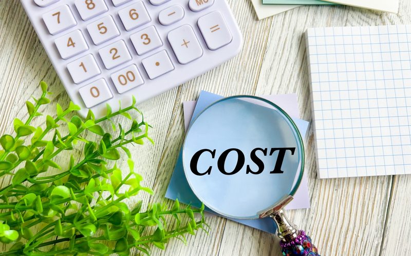電卓と「COST」の文字。採用・教育コストの負担