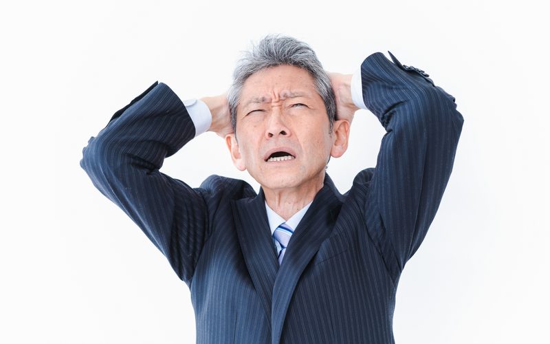頭を抱えるビジネスパーソン。急な欠員に対応できず困る