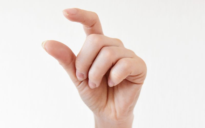 指で「少しだけ」を示す手。一部だけ委託したいイメージ